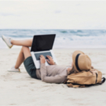 Woman on her laptop at the beach